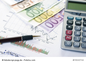 Pen, stock charts, calculator and euro money on desk